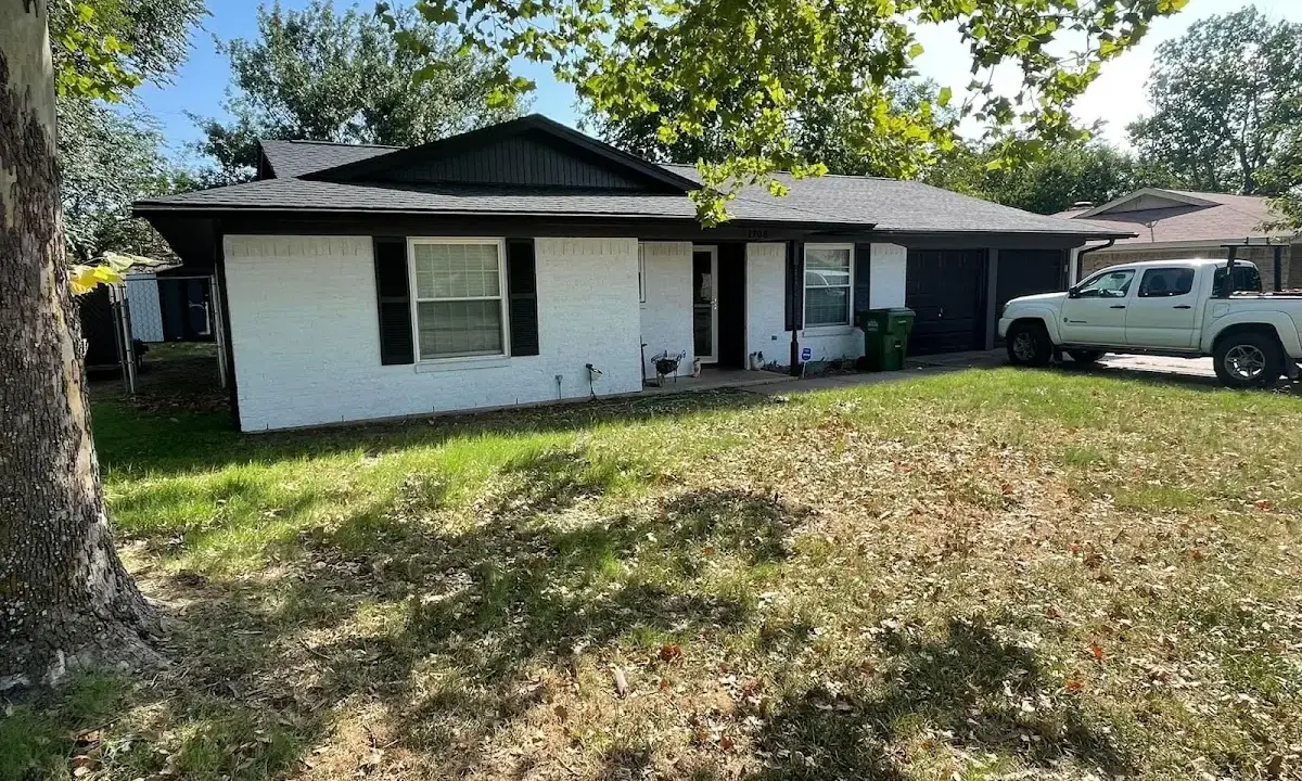 Professional roofing crew working on a residential roof in Iola